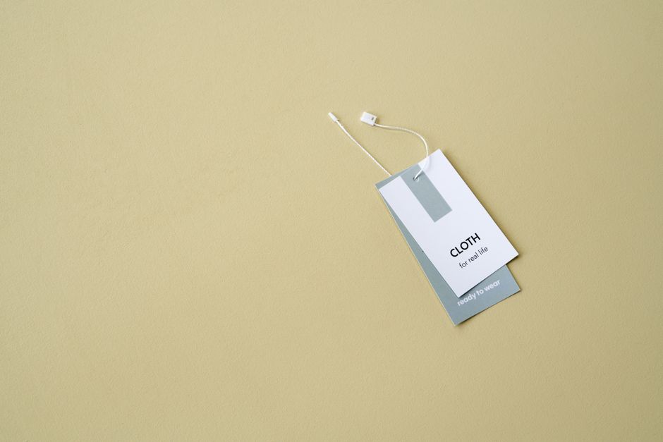 A stylish clothing label on a muted background offers ample copy space.